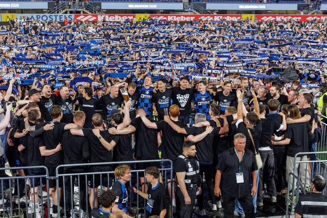 帕德博恩球队成功重返德甲联赛引发球迷狂热庆祝，现场出现球迷冲入球场欢呼的震撼场面，有目击者称一名球迷疑似被警方强行带离并遭暴力对待